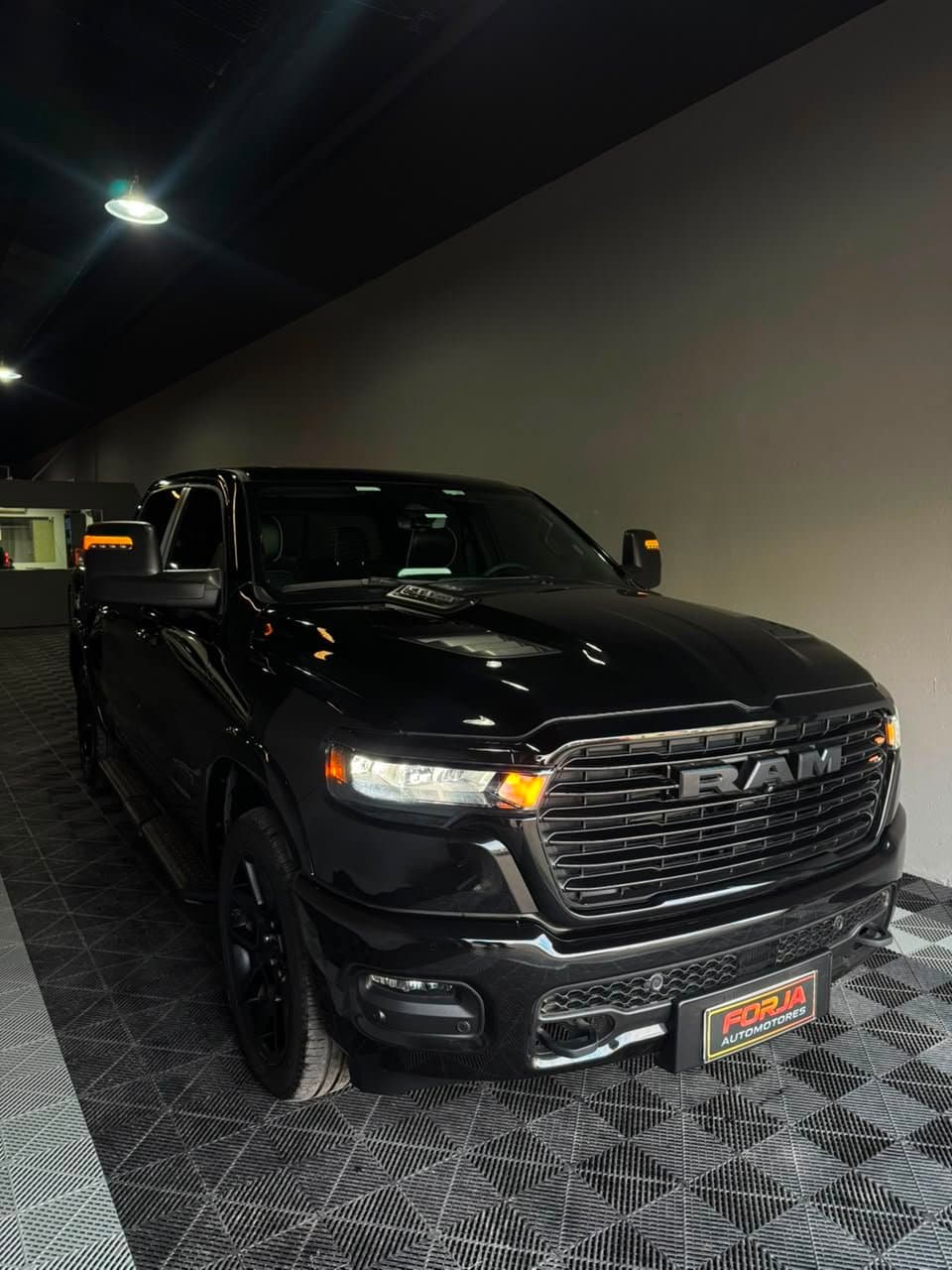 RAM 1500 Night Edition negra, tres cuartos de frente, en el showroom de Forja