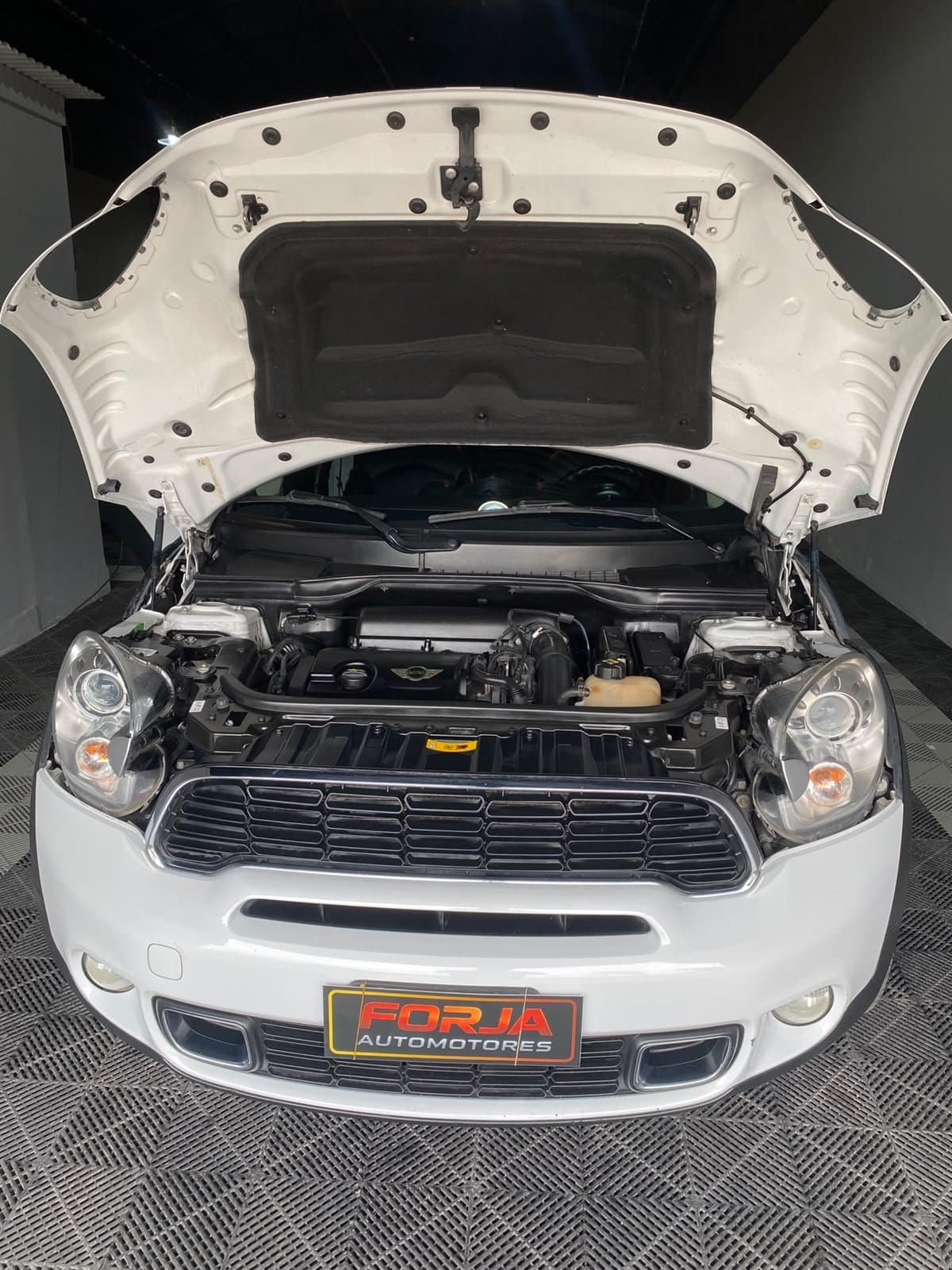 Mini Countryman blanco de frente con el capot abierto y el motor a la vista