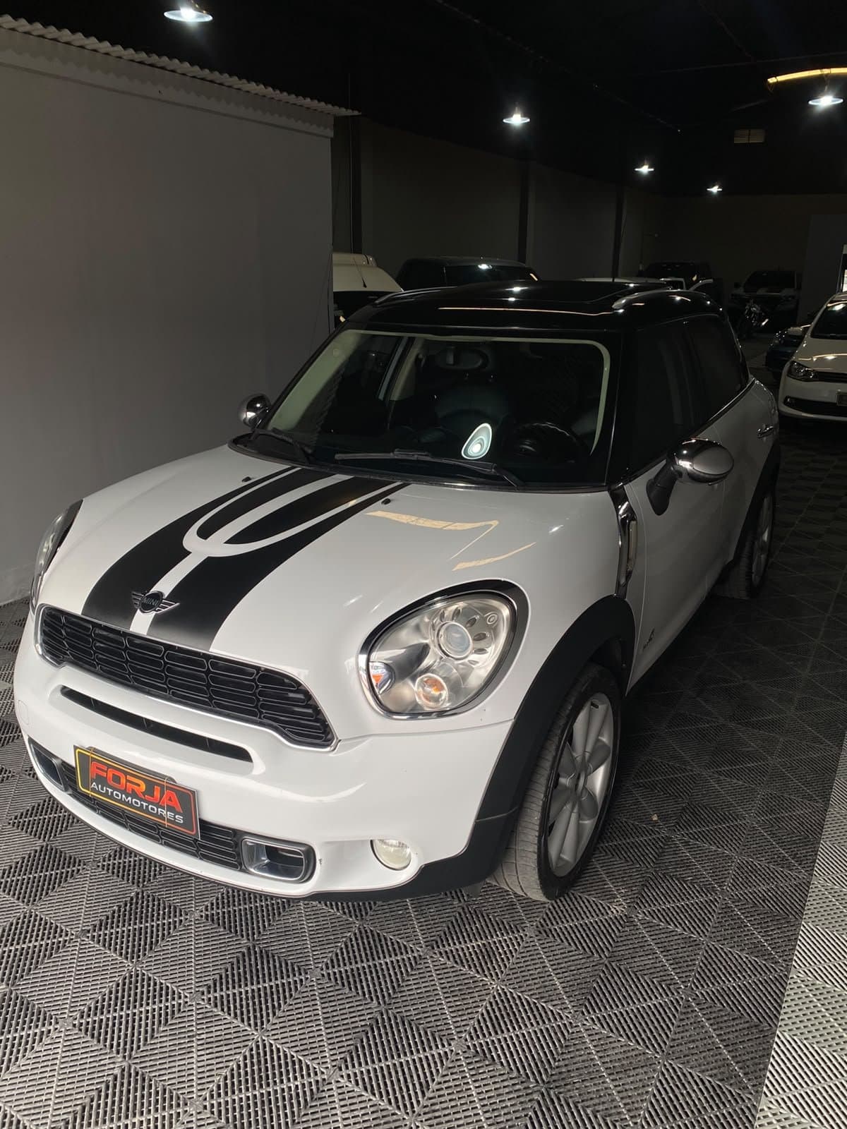 Mini Countryman blanco con techo negro, frente tres cuartos, en el showroom
