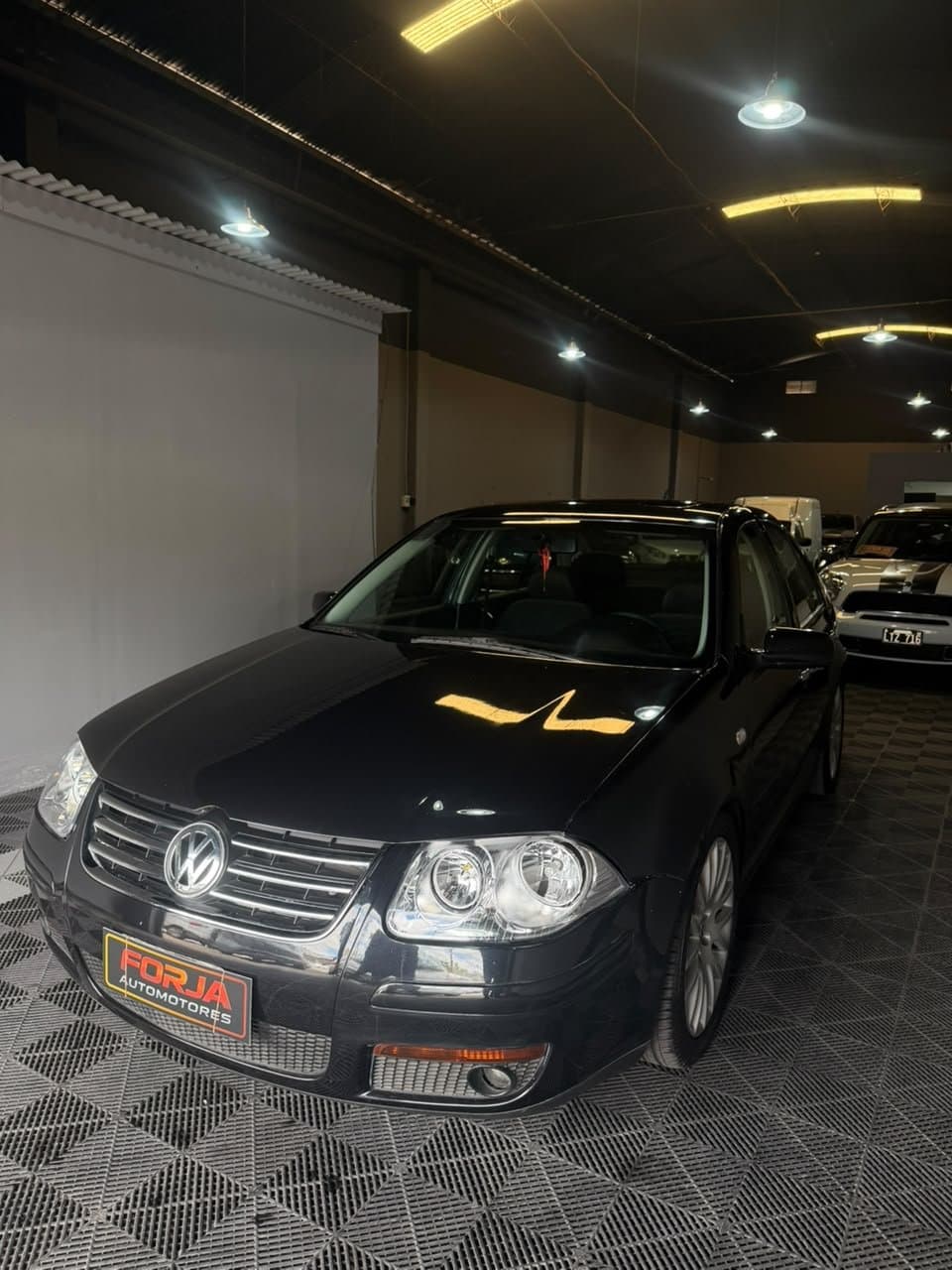 Volkswagen Bora negro, frente tres cuartos, en el showroom